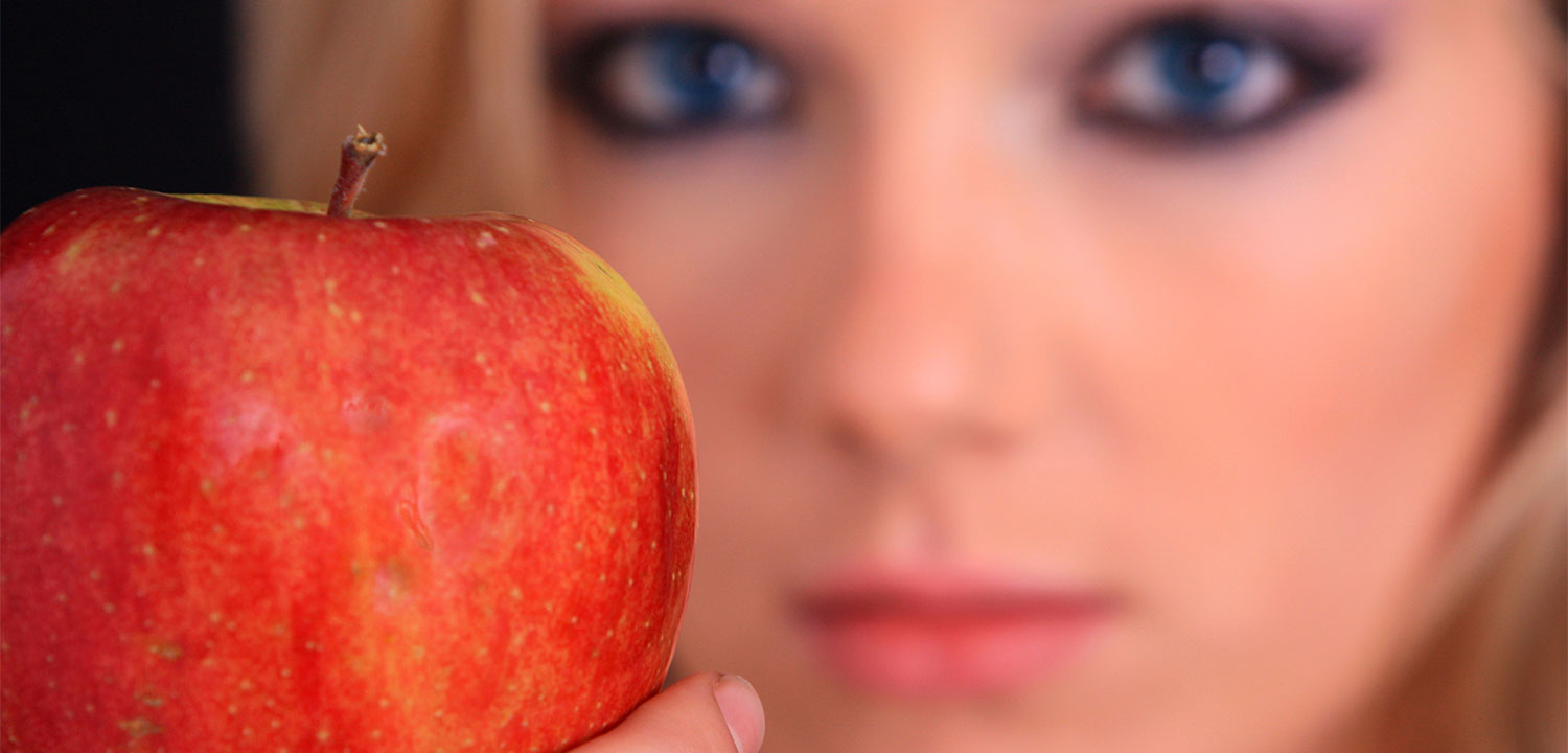 Une femme qui tient une pomme rouge